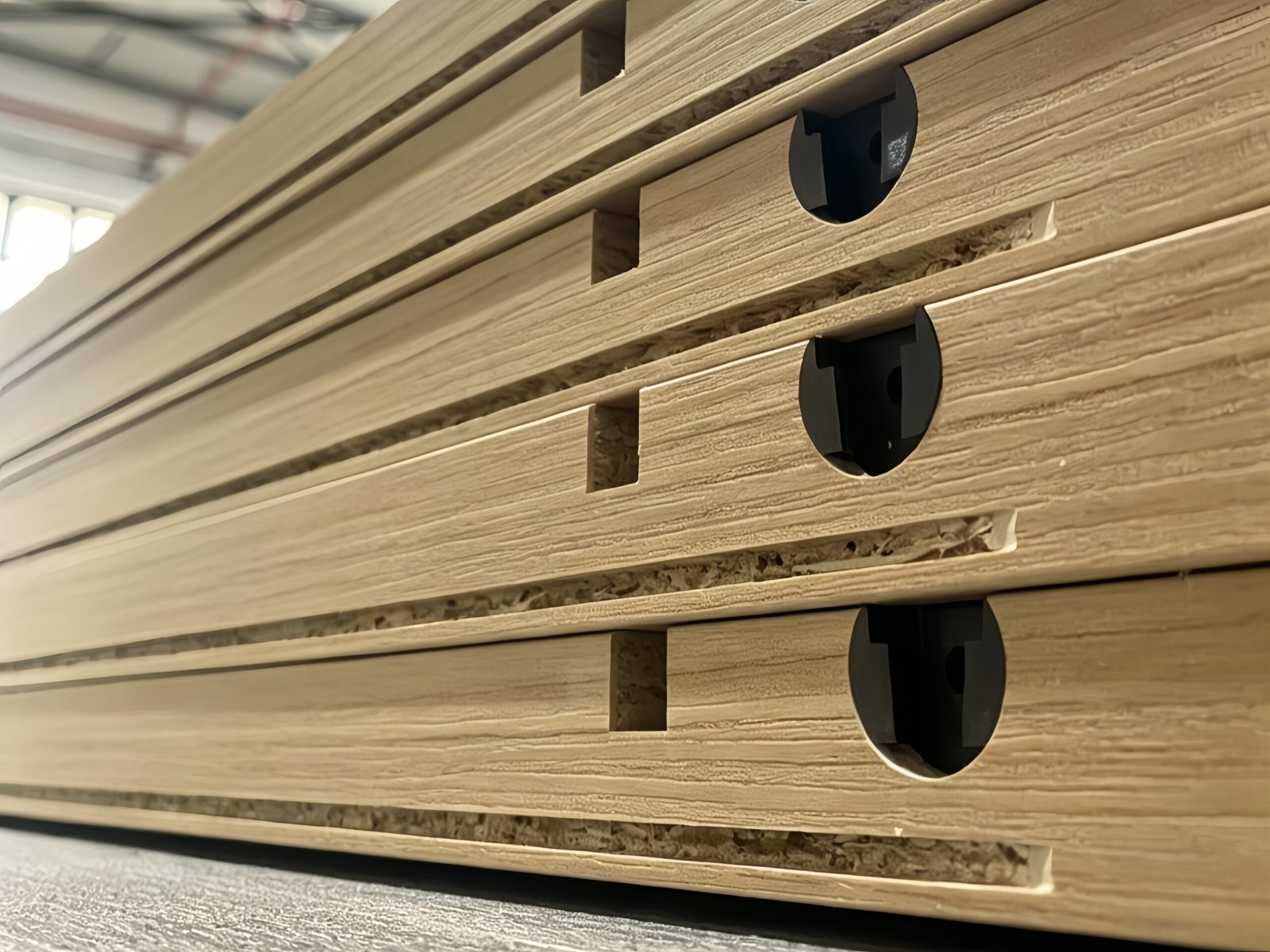 Stack of precision drilled wooden cabinet panels after CNC machining based on approved shop drawings
